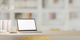 Laptop and books on a table A laptop, books, a reading lamp and a coffee cup on a table